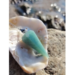 Pendule en amazonite bleu-vert dans un coquillage sur rocher en Bretagne, photo apaisante évoquant douceur, clarté et équilibre intérieur.
