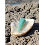Pendule en amazonite bleu-vert présenté dans un coquillage sur roche en Bretagne, image douce inspirant calme, intuition et harmonie.