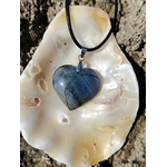 Pendentif cœur en labradorite posé sur un coquillage dans un décor minéral naturel, bijou aux reflets profonds associé à l’intuition, à la présence à soi et à la stabilité.
