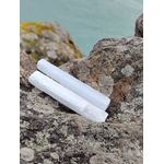 Deux baguettes de sélénite sur rochers en Bretagne sous ciel bleu, éclat nacré naturel, douceur intérieure et énergie limpide.