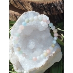 Bracelet Morganite 6 mm présenté sur géode blanche avec écorce et herbes, perles pastel aux reflets doux, bijou en pierre naturelle relié à la paix intérieure, à la tendresse et à l’équilibre émotionnel.