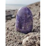 Lépidolite forme libre violette posée sur roche bretonne en bord de mer, pierre naturelle associée au calme intérieur, au recentrage et à la douceur émotionnelle.