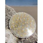 Plateau de rechargement orgonite sélénite sur mousse en forêt en Bretagne, disque blanc irisé avec Fleur de Vie dorée, calme mental et purification énergétique.