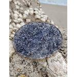 Plateau orgonite obsidienne noire sur rocher marin en Bretagne avec plage floue en fond, face minérale sombre sans motif visible, équilibre intérieur et énergie stabilisante.