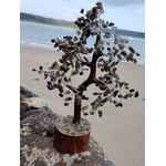 Arbre de vie labradorite photographié en lumière naturelle en forêt en Bretagne, socle rond en bois et pierres chatoyantes, recentrage et apaisement du mental.