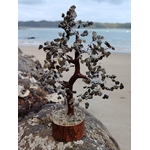 Arbre labradorite en gros plan sur rondelle de bois en forêt, feuillage minéral bleu ardoise et branches métal, clarté mentale et protection.