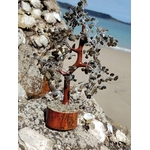 Arbre labradorite avec base en bois en décor naturel breton, ramure minérale en gros plan et reflets bleu acier, intuition et protection subtile.