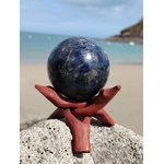 Sphère iolite ou cordiérite sur roche marine en Bretagne avec socle en bois, pierre bleu nuit aux éclats nuancés, sérénité mentale et intuition apaisée.