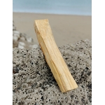 Bâton de Palo Santo du Pérou dressé sur roche marine en Bretagne, bois blond naturel, assainissement énergétique et retour au calme.