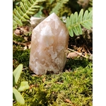 Pointe agate fleur de cerisier sur mousse avec fougères en décor naturel, pierre rose poudré aux motifs floraux, apaisement intérieur et épanouissement personnel.