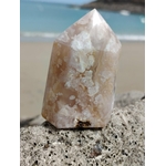Pointe agate fleur de cerisier sur rocher en bord de plage, pierre rose beige polie aux dessins fleuris, apaisement du mental et énergie tendre.