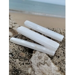 Baguette de sélénite tenue en main en Bretagne en lumière naturelle, pierre blanche translucide, apaisement émotionnel et sensation de légèreté.