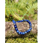 Bracelet Lapis Lazuli 6 mm présenté sur branche en sous-bois avec mousse et fougères, perles bleu profond veinées, intuition et parole apaisée.