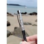 Stylo en Labradorite présenté en lumière naturelle, éclats irisés de la pierre, intuition renforcée et expression plus fluide.