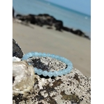 Bracelet Aigue-Marine 6 mm en lumière naturelle sur décor côtier, perles bleu clair, apaisement du mental et énergie douce.