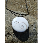 Pendentif œil de Sainte Lucie rond blanc sur cordon noir, posé sur roche granitique en lumière naturelle, coquillage marin porte-bonheur aux reflets doux, symbole de protection et d’intuition.