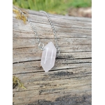 Collier en quartz rose sur chaîne argentée, pendentif allongé posé sur une branche avec mousse verte, évoquant tendresse, réconfort intérieur et harmonie affective.