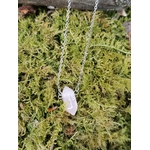Pendentif pointe en quartz rose sur chaîne argentée suspendu sous une branche, pierre rose posée sur mousse végétale, évoquant apaisement du cœur, sérénité émotionnelle et douceur affective.