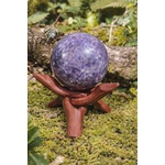 Sphère lépidolite sur mousse en forêt en Bretagne avec support en bois, pierre lilas aux nuances violettes, sérénité mentale et douceur intérieure.