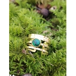 Bague dorée triple ligne avec pierre verte sur mousse en forêt, acier inoxydable ajustable et cabochon effet malachite, apaisement intérieur et élégance végétale.