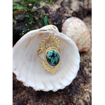 Bague dorée ajustable solaire avec pierre verte ovale sur coquillage au bord de mer en Bretagne, acier inoxydable lumineux, élégance naturelle et harmonie intérieure.