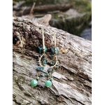 Boucles d’oreilles dorées turquoise africaine sur tronc en forêt, pierres naturelles bleu-vert et pampilles fines, douceur émotionnelle et allure bohème