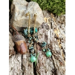 Boucles d’oreilles turquoise africaine et métal doré sur bois brut avec gland et mousse, perles facettées vert tendre et pierres marbrées, équilibre intérieur et charme naturel.