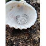Bague ajustable argentée fleur avec strass sur bois naturel en extérieur, acier inoxydable éclatant et design floral ajouré, élégance discrète au quotidien.