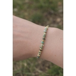 Bracelet doré en turquoise africaine photographié sur mousse en forêt, perles vert sauge et bleu minéral, sérénité intérieure et élégance naturelle.
