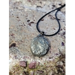Pendentif pyrite naturelle posé en extérieur en Bretagne, pierre brillante argentée sur cordon noir, pierre de protection douce et de confiance personnelle.