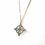 Pendentif nœud de sorcière doré en acier inoxydable sur fond clair, bijou ésotérique symbole de protection, d’harmonie et de force intérieure.