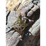 Pendentif nœud de sorcière en acier inoxydable doré en mise en situation, talisman symbolique lié à l’ancrage et à la force personnelle.