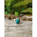 Bague chrysocolle argent 925 réglable sur bois clair avec feuillage en arrière-plan, bijou pierre naturelle bleu vert, apaisement, communication et équilibre émotionnel.