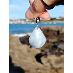 Pendentif calcite bleue naturelle en gros plan sur cordon noir, pierre polie bleu nuageux, détente intérieure et communication douce.