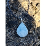 Pendentif calcite bleue naturelle porté sur cordon noir en lumière naturelle, pierre goutte bleu tendre, communication apaisée et douceur émotionnelle.