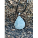 Pendentif calcite bleue naturelle sur support en bois avec décor extérieur en Bretagne, bijou bleu clair apaisant favorisant expression et calme.