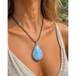 Pendentif calcite bleue naturelle porté sur cordon noir en lumière naturelle, goutte bleu pastel, calme intérieur et douceur émotionnelle.