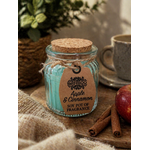 Bougie parfumée Pomme Cannelle en pot en verre sur table en bois avec tasse, pomme et cannelle, senteur épicée douce et atmosphère chaleureuse.