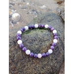 Bracelet Lépidolite Kunzite en pierres naturelles sur roche bretonne, mélange de perles mauves et roses, douceur émotionnelle et sérénité.