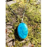 Pendentif chrysocolle argent 925 sur chaîne posé sur mousse en forêt, pierre ovale bleu turquoise naturelle, recentrage et apaisement du cœur.