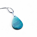 Pendentif malachite naturelle en goutte sur fond blanc, pierre verte aux bandes concentriques, transformation, stabilité et protection.