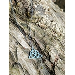 Pendentif Triquetra argent 925 photographié en gros plan, bijou celtique ajouré aux courbes fines, recentrage, solidité intérieure et élévation.