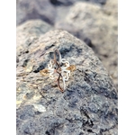 Bague nœud de sorcière dorée en acier inoxydable posée sur rocher en Bretagne, bijou ésotérique ajouré symbole de protection, équilibre et harmonie intérieure.
