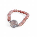 Bracelet Pierre de Soleil création Magic Gaïa sur fond blanc, perles pêche lumineuses et médaillon central, joie intérieure et confiance en soi.
