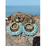 Boucles d’oreilles pendantes dorées éventail tissé avec pierre bleu turquoise sur fond clair, bijou bohème chic lumineux et élégant