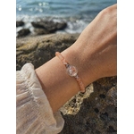 Bracelet Pierre de Soleil création Magic Gaïa porté au poignet en bord de mer en Bretagne, perles pêche lumineuses et cabochon central scintillant, joie et confiance en soi.