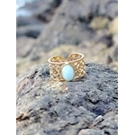Bague réglable Amazonite photographiée sur la côte bretonne, cabochon ovale bleu-vert, acier inoxydable doré et allure bohème chic.