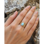 Bague dorée Amazonite portée sur la main, cabochon bleu-vert et acier inoxydable ajouré pour une allure naturelle et élégante.