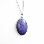 Pendentif Lépidolite naturelle ovale violette sur fond blanc, pierre de calme, de lâcher-prise et de douceur émotionnelle