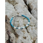 Bracelet fin en apatite facettée et opale sur décor naturel breton, création Magic Gaïa bleue et irisée, parole fluide et intuition.